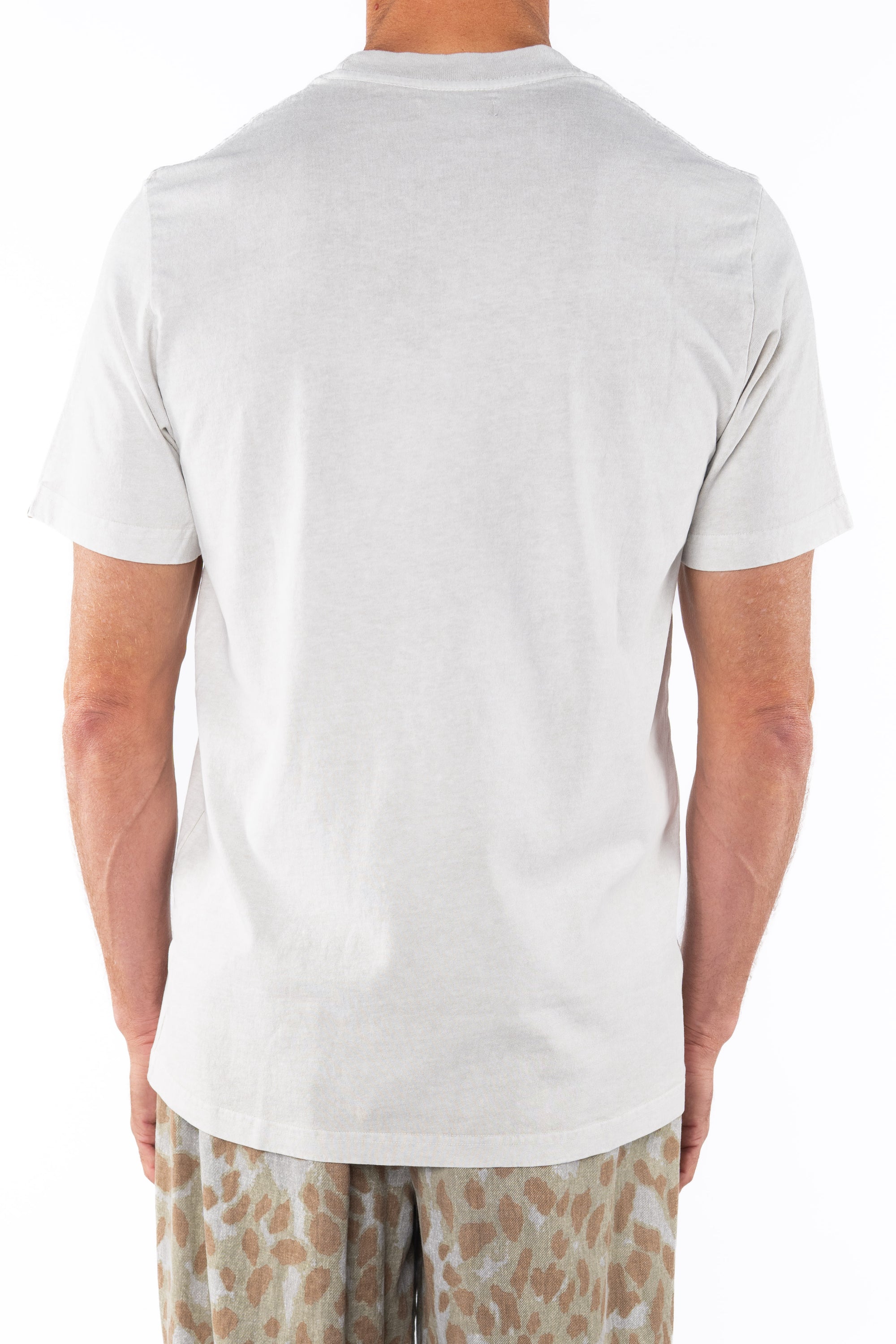 Back shot of man wearing a Crewneck T-shirt in cream with a leopard pants on a white background.