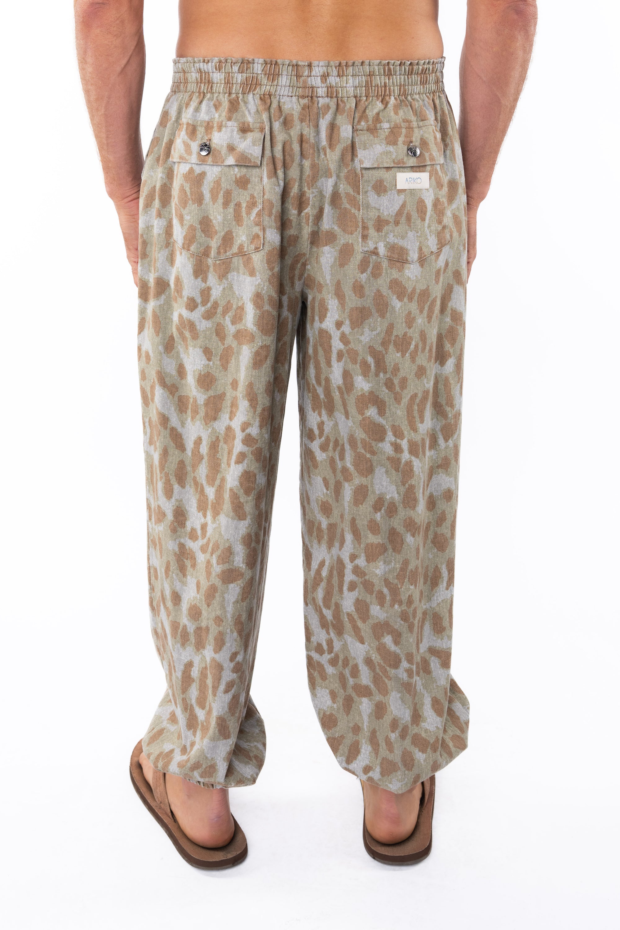 Back shot of a man wearing Leopard Camo day pants. 