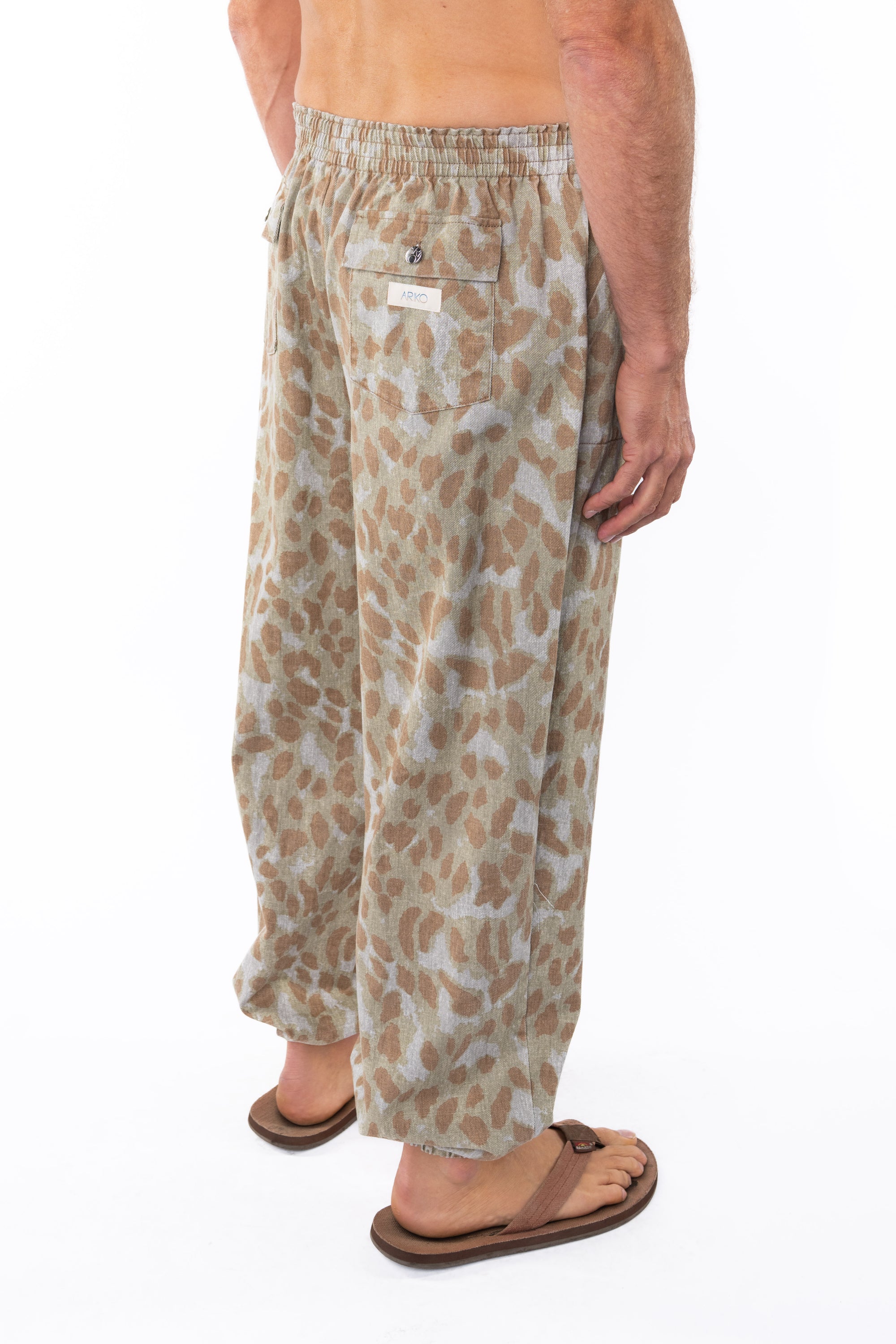 Side back shot of a man wearing Leopard Camo day pants. 