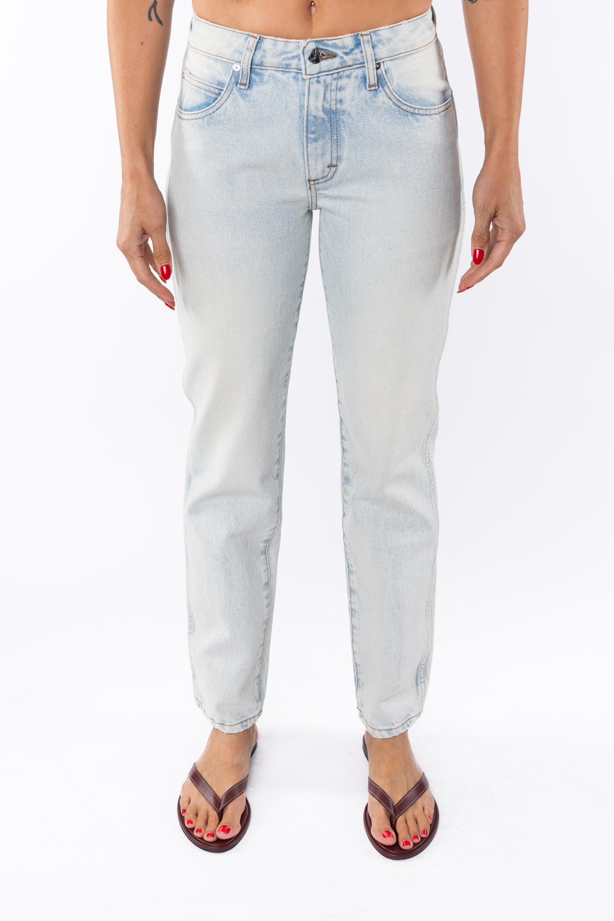 Woman wearing light denim washed jeans on a white background