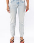 Woman wearing light denim washed jeans on a white background