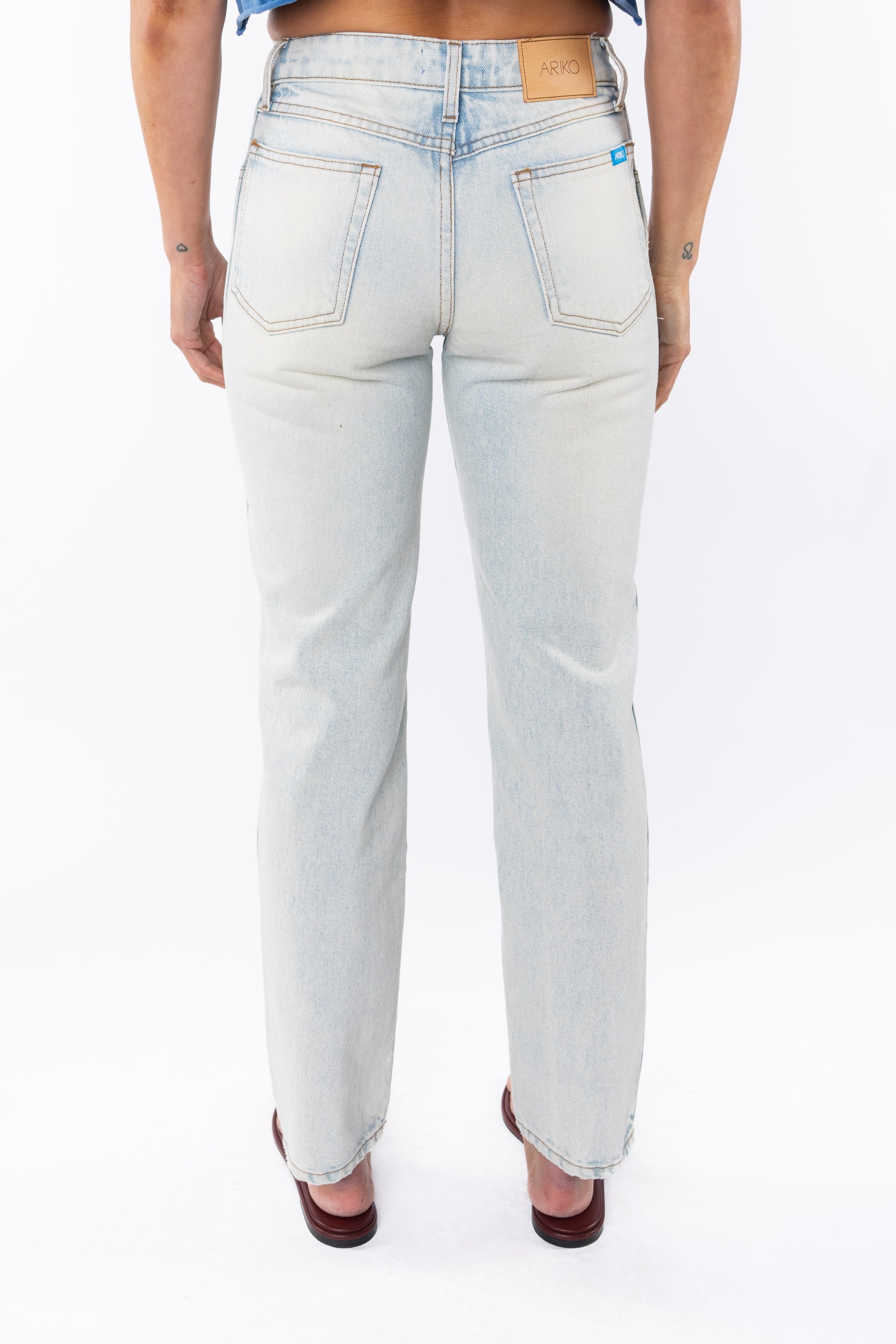 Light denim washed jeans worn by a woman on a white background