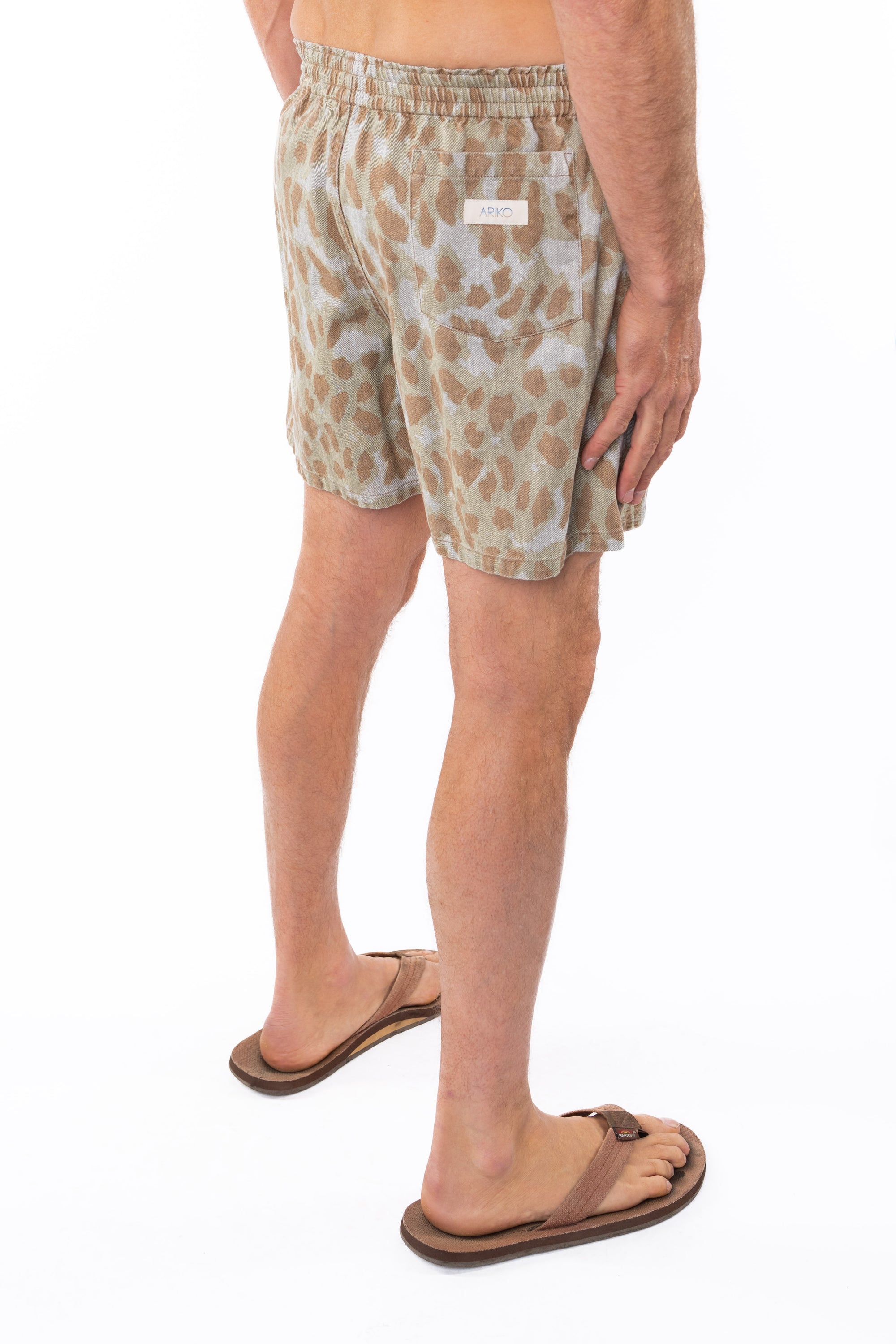 Side back view of a man wearing leopard camo printed day shorts on a white background