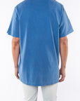 Back shot of a woman wearing Beach Crewneck T-shirt in Blue Wave with Surf Jeans.
