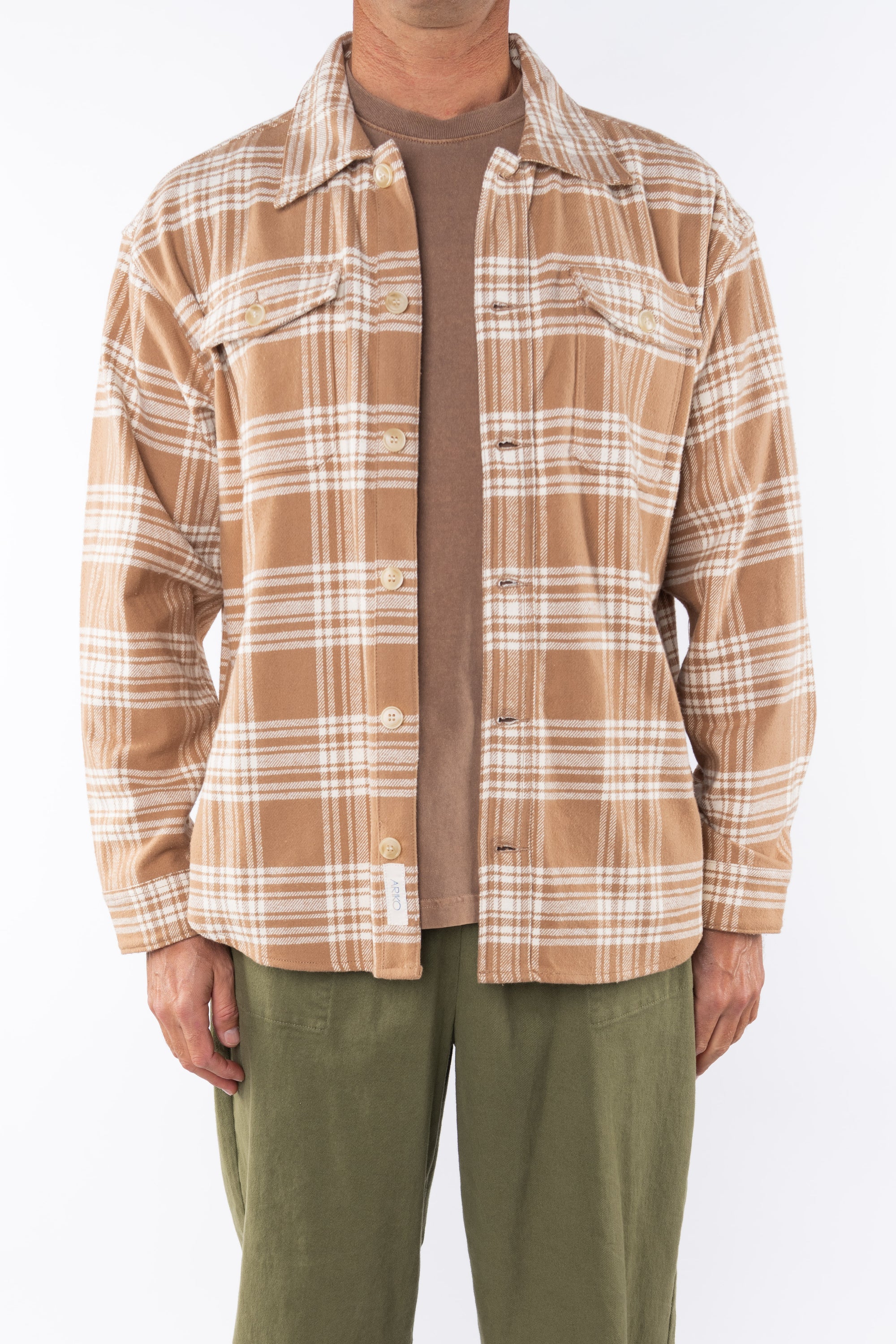 Man wearing Bucky Split Hem Shirt Jacket in White/Beige Plaid with Beach Crewneck T-shirt Brownstone with Army Green Day pants. 