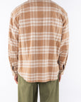 Back shot of a man wearing Bucky Split Hem Shirt Jacket in White/Beige Plaid with Army Green Day pants. 