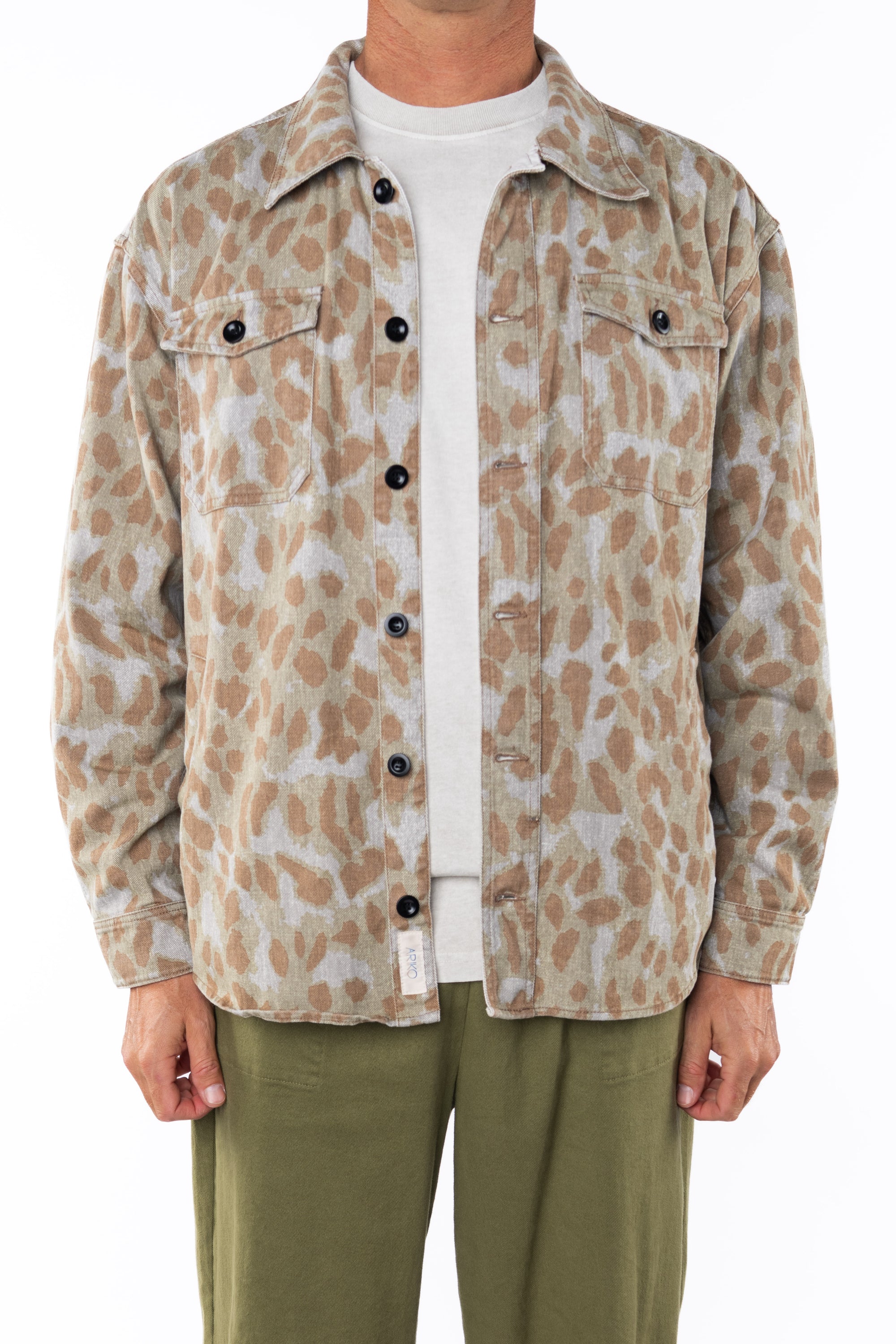 Person wearing a leopard camo bucky patterned jacket over a white shirt with army green day pants on a white background
