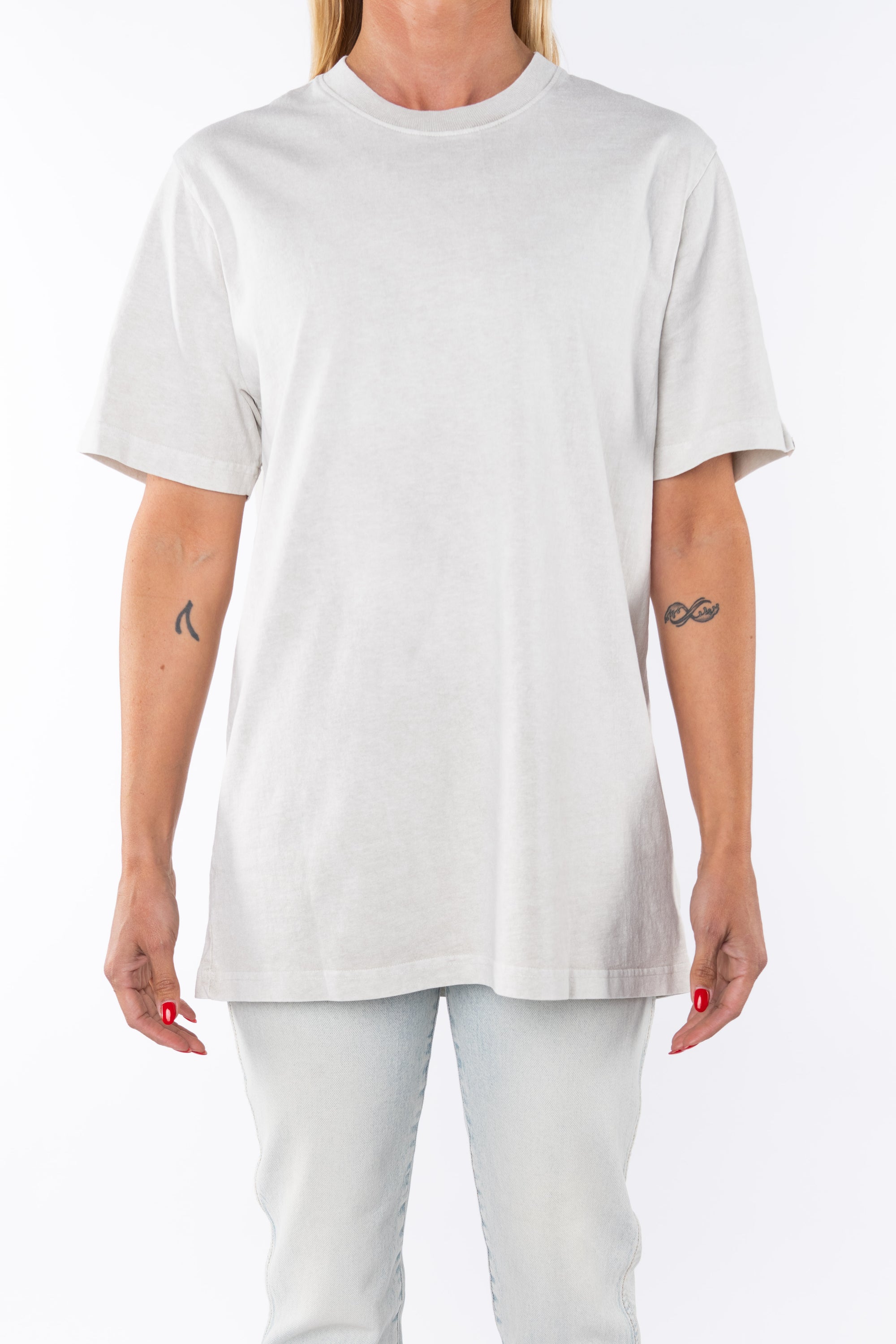 Woman wearing an oversized Crewneck T-shirt in cream with light washed denim jeans.