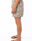 Side shot of a woman wearing leopard  shorts on a white background. 
