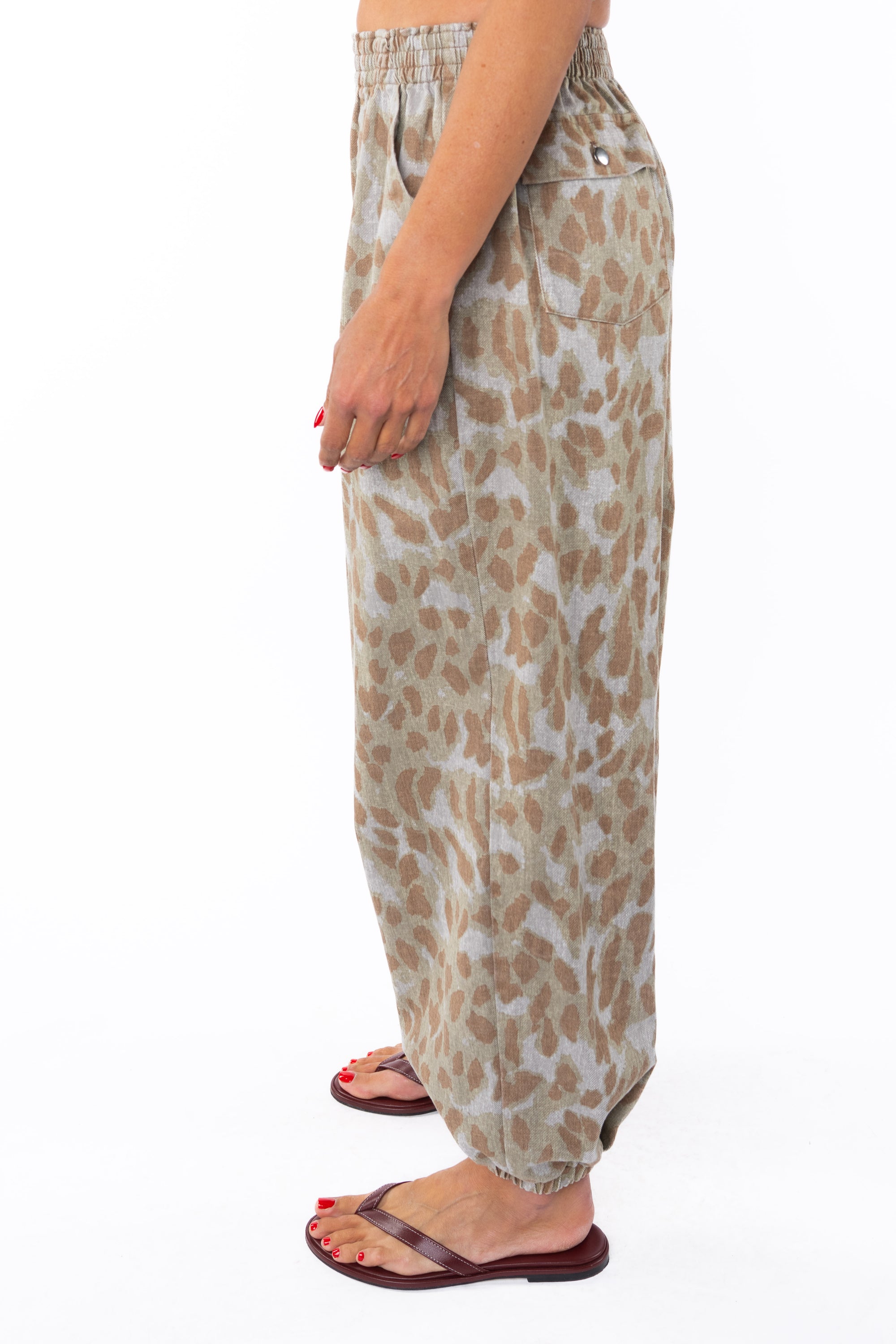Side shot of a woman wearing Leopard Camo day pants on a white background
