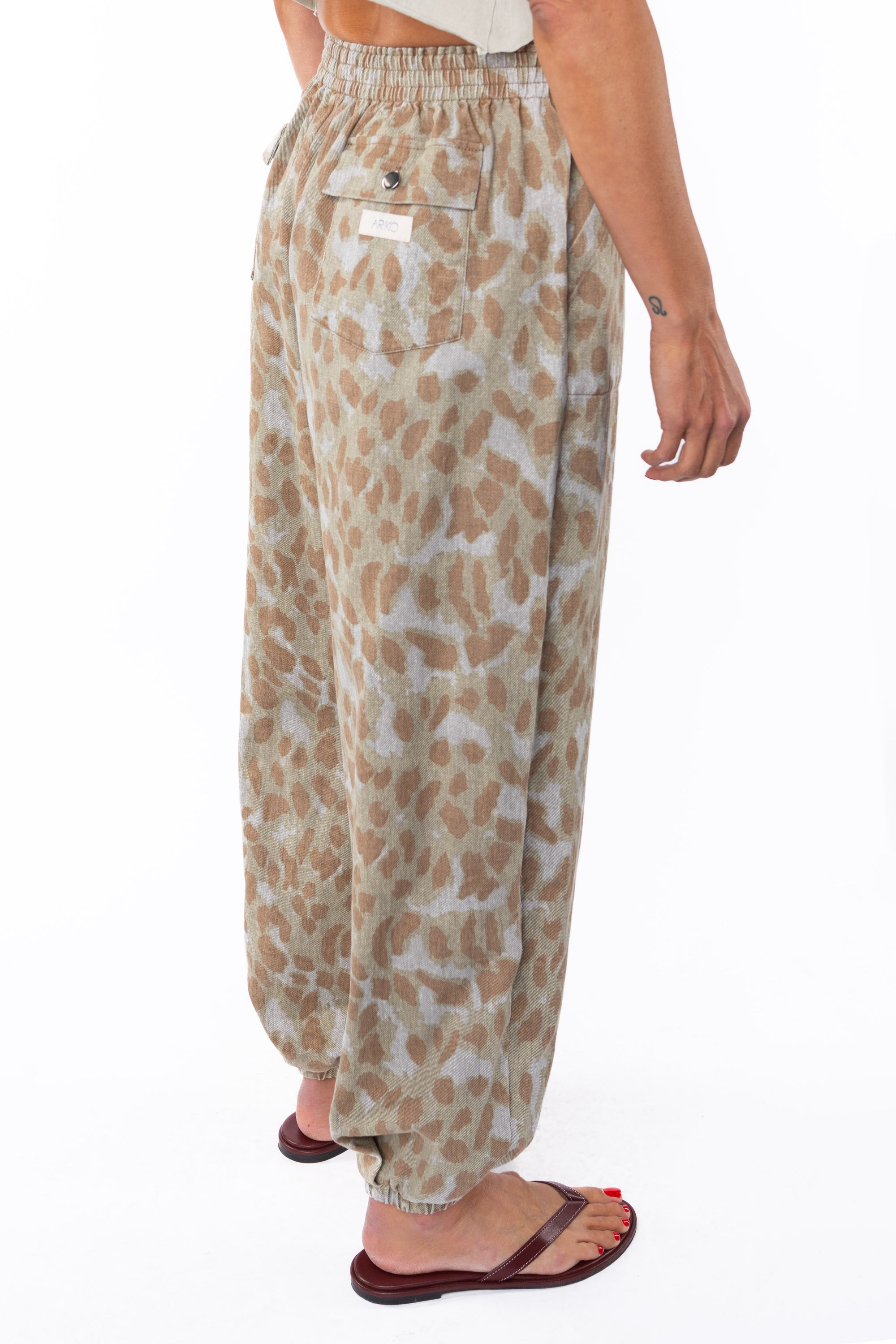 Back side shot of a woman wearing Leopard Camo day pants on a white background