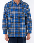 Man wearing the Bucky Heavyweight Blue/black flannel shirt with a navy day pants on a white background
