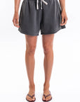 Woman wearing dark gray french terry day shorts on a white background