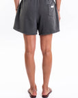 Back view of a person wearing dark gray french terry day shorts on a white background