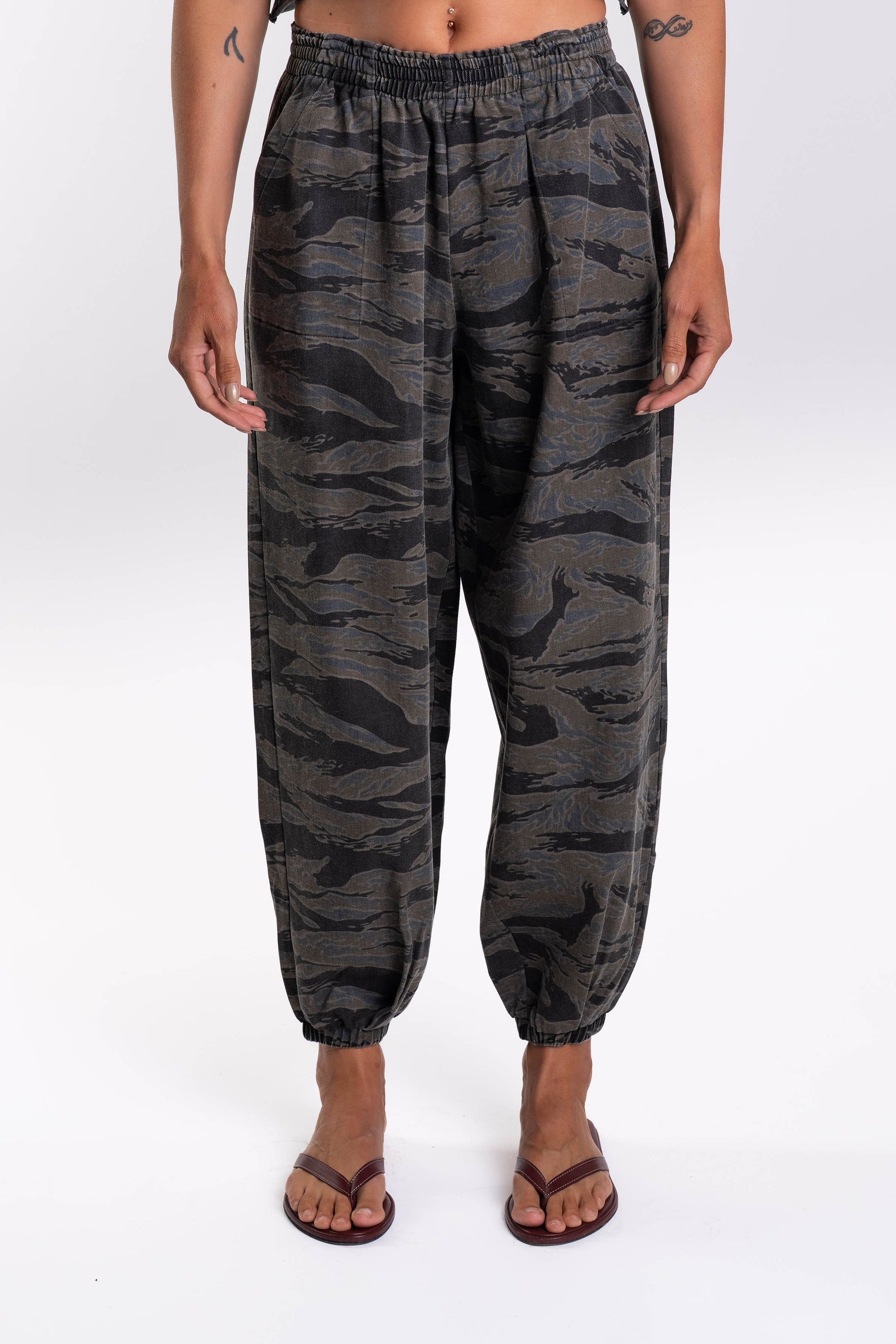 Woman wearing Ocean Tiger Camouflage pants worn on a white background