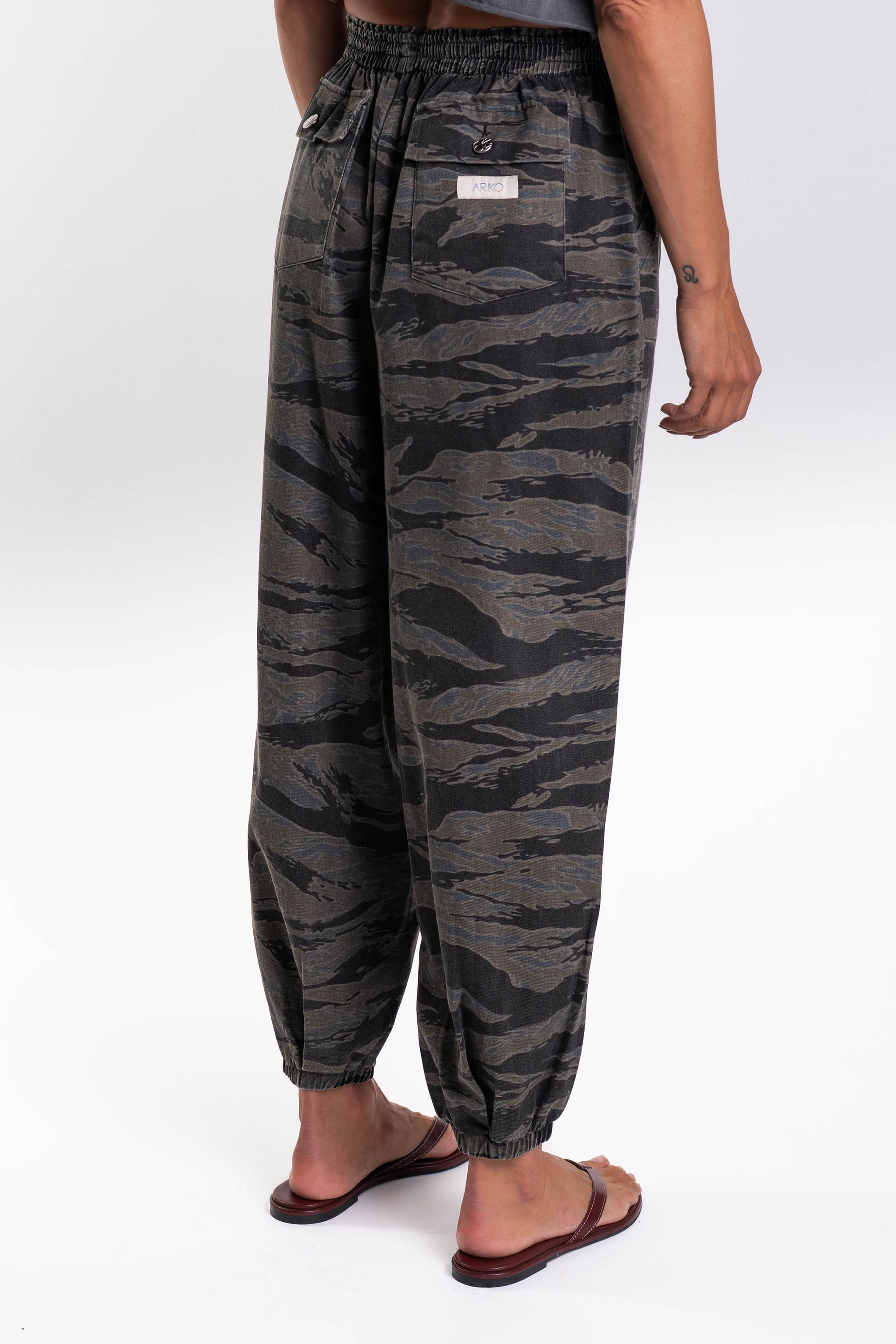 Side back view of ocean tiger camo pants worn by a person on a white background