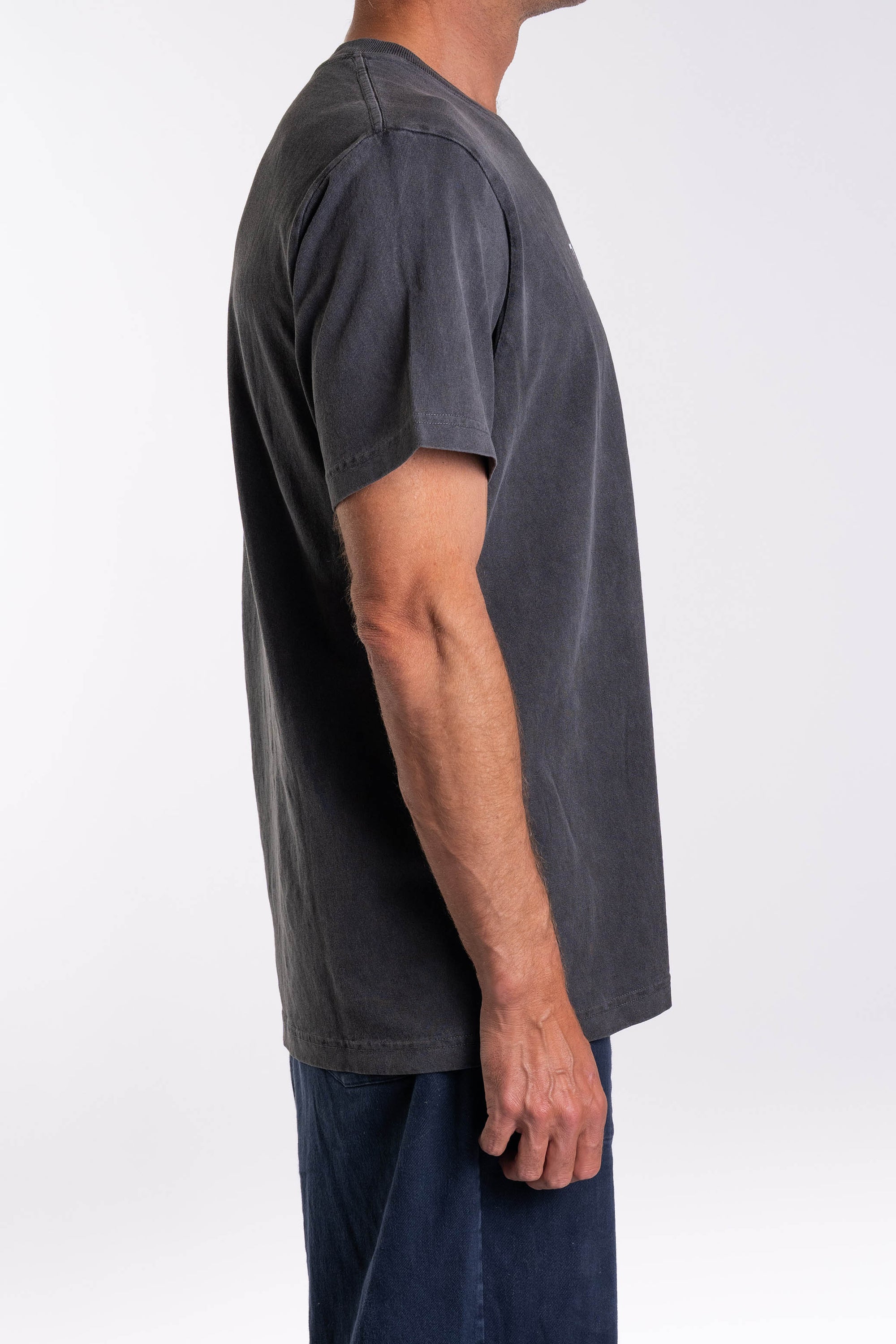 Side view of a person wearing a dark gray t-shirt on a white background