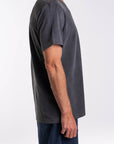 Side view of a person wearing a dark gray t-shirt on a white background