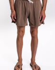 Brown french terry day shorts worn by a person on a white background
