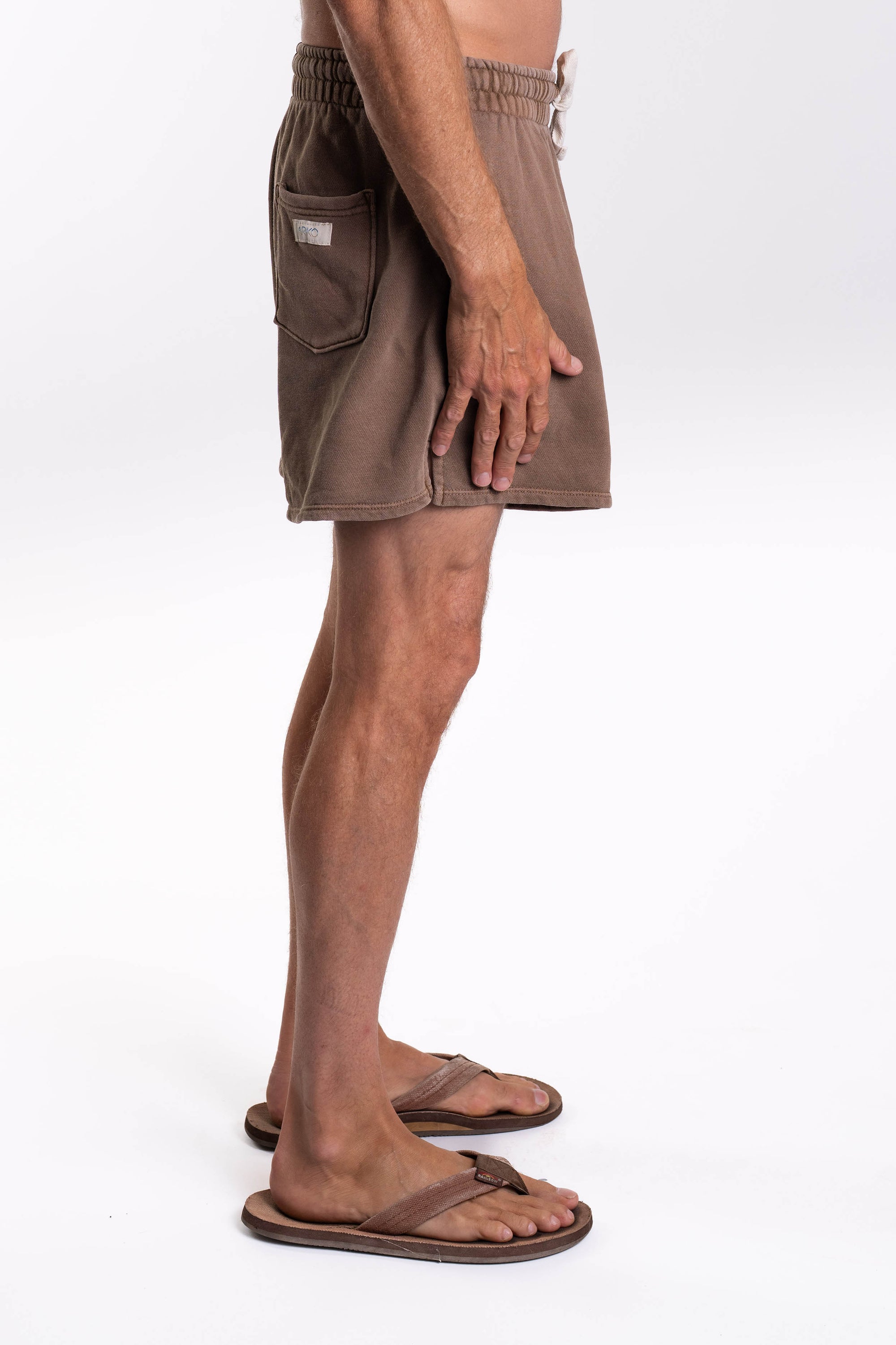 Brown french terry day shorts worn by a person on a white background
