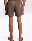 Back view of French terry brown shorts worn by a person on a white background
