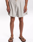 Person wearing beige french terry day shorts on a white background