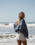 woman wearing the Bucky Blue/black flannel with denim day skirt on a beach